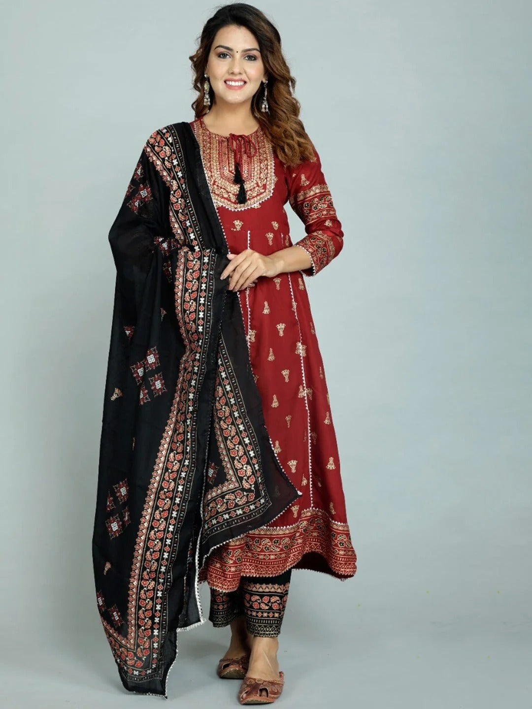 Woman wearing maroon printed anarkali kurta with black pants and dupatta